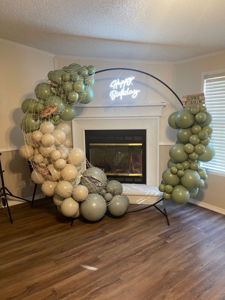 balloons are arranged in the shape of an arch with a fireplace and neon sign above it