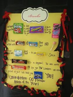 a bulletin board with candy bars and candies on it's side, tied in red ribbon