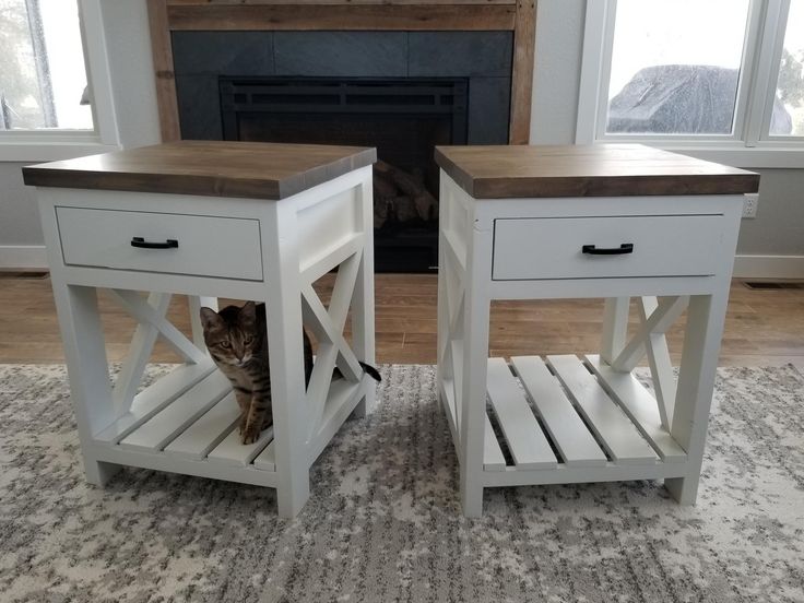 a cat sitting on top of a wooden table next to a fire place in a living room