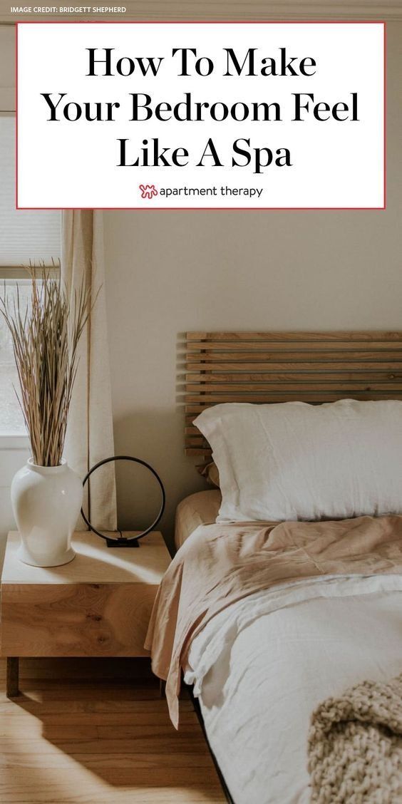 a bed room with a neatly made bed next to a window and a wooden table