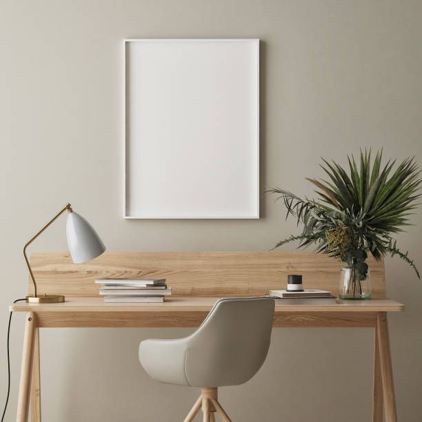 a painting hanging on the wall above a desk with a chair and potted plant