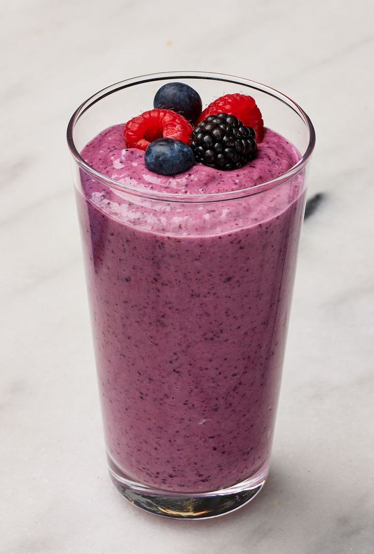 a smoothie is garnished with berries and blackberries