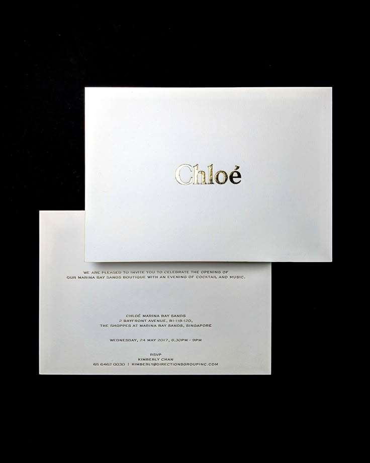 two white envelopes with gold foil on them