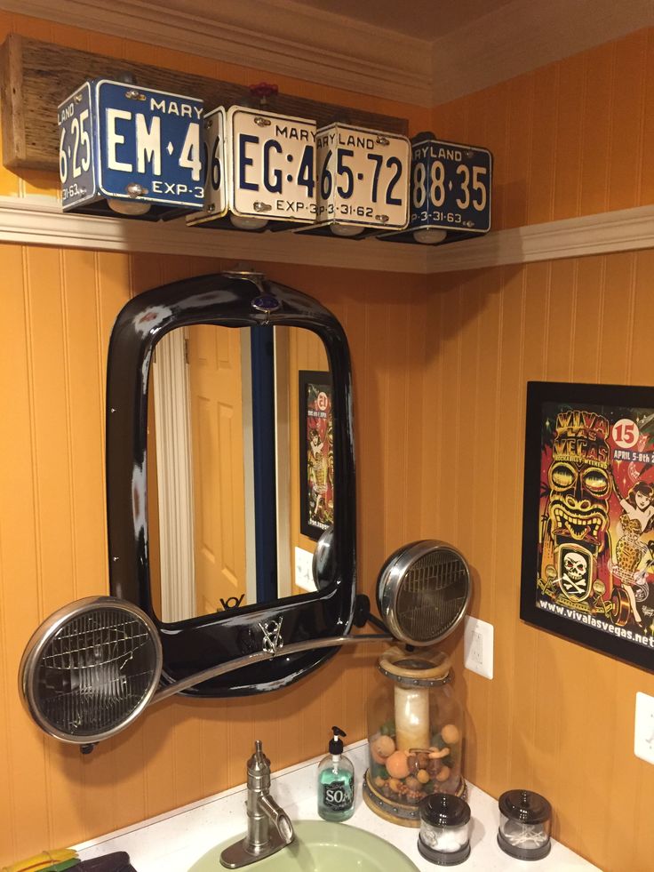 a bathroom sink with a mirror and two license plates above it