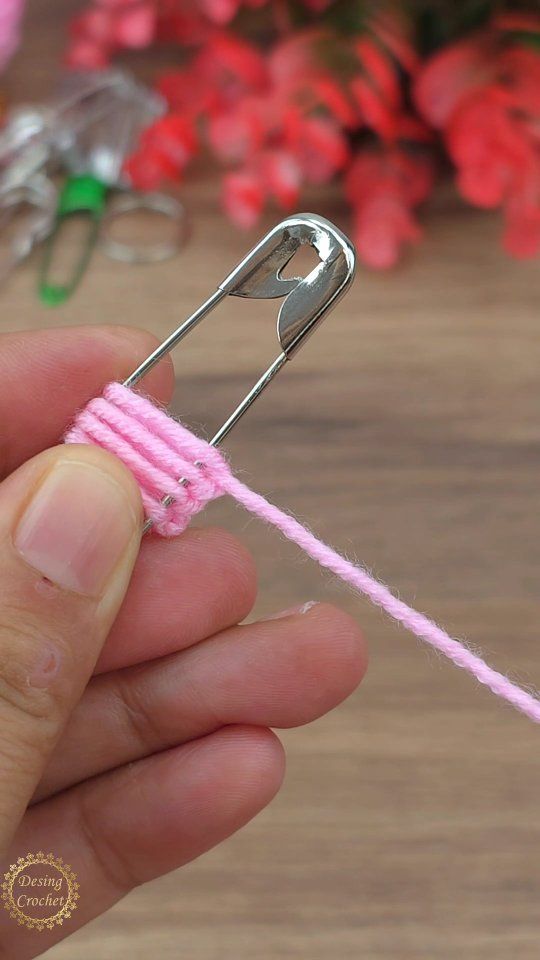 a person holding a pink string with a pair of scissors in the middle of it