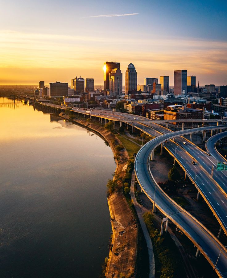 an aerial view of the city skyline and freeways at sunset, with cars driving on it