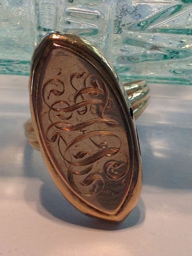 This fascinating ring is actually made from two separate components.    The top part, a marquise-shaped hollow "pillow" of 14K yellow gold, was originally (I think) part of an antique stick pin, and the bottom part is a vintage 10K, 3-stone ring, minus the stones, that was soldered onto it.  As weird as this sounds, the whole thing works.   The top is decorated with beautiful hand-engraved initials.  This is the kind of engraving you just can't get anymore without spending a small fortune, and i Elegant 14k Gold Ceremonial Rings, Elegant Ceremonial Rings In 14k Gold, Etched 14k Rose Gold Jewelry, 14k Gold Bronze Ring Jewelry, Bronze 14k Gold Ring, Etched Rose Gold Jewelry In 14k Gold, Heirloom Jewelry With Engraving Option, Oval White Gold Engraved Collectible Ring, Ceremonial Yellow Gold Engraved Ring With Polished Finish