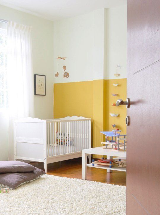 a baby's room with yellow walls and white furniture, including a crib