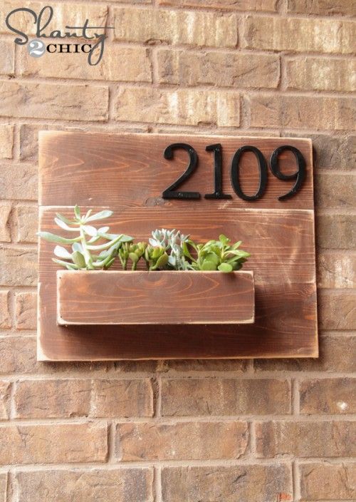 a brick wall with a planter on it and the number 2099 written in black