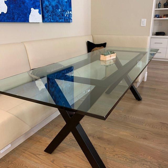 a glass table sitting on top of a hard wood floor next to a white couch