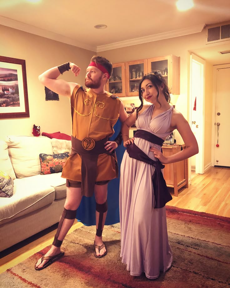 a man and woman dressed up as roman soldiers posing for a photo in their living room