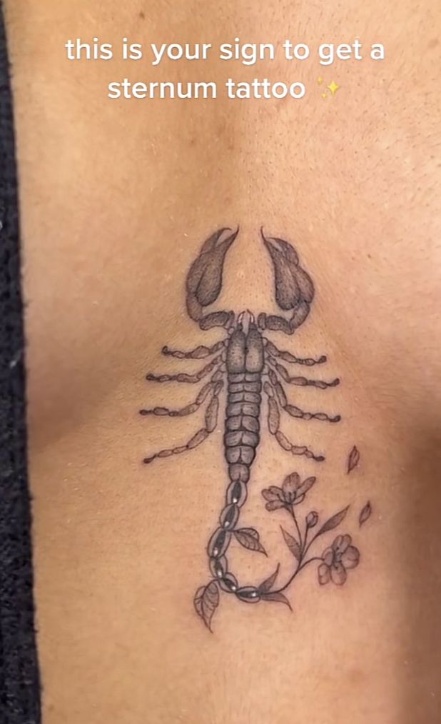 a scorpion tattoo on the back of a woman's stomach