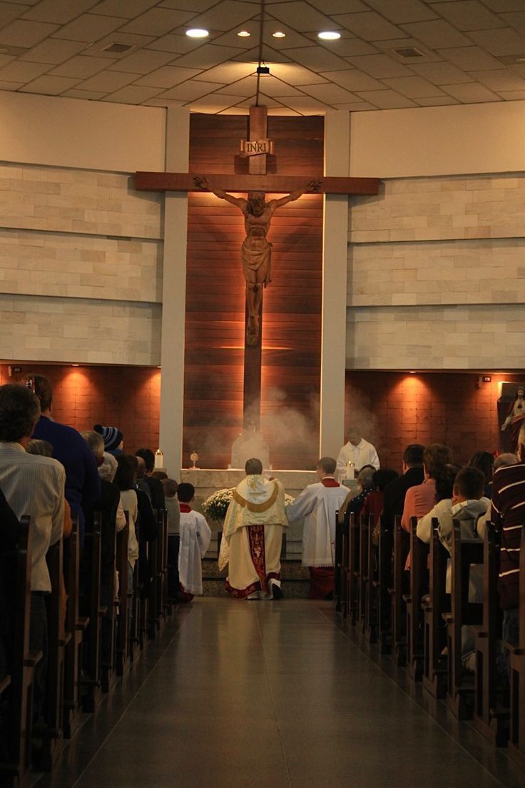 a group of people standing in front of a church alter with the cross above them