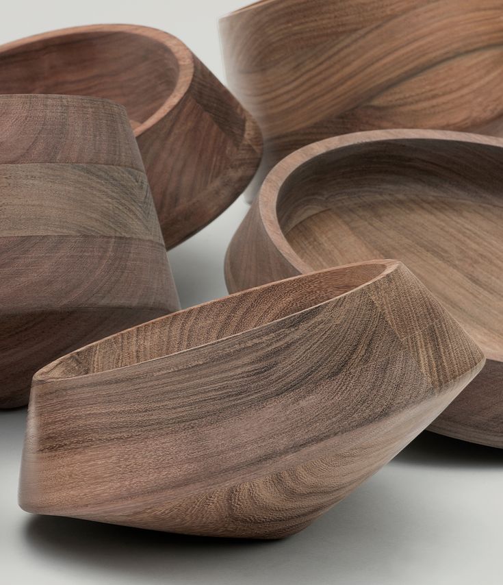 several wooden bowls stacked on top of each other in the shape of curved lines and curves