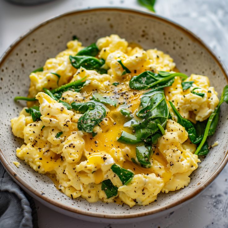 a bowl filled with scrambled eggs and spinach