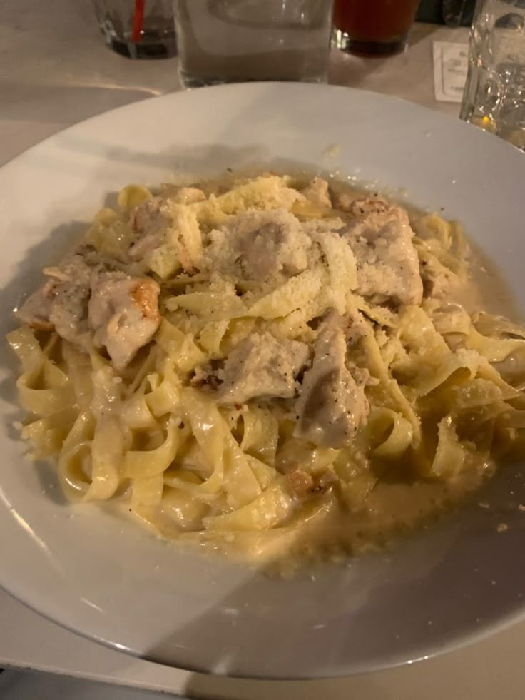 a white plate topped with pasta and meat