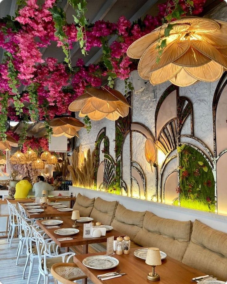 the interior of a restaurant with tables, chairs and umbrellas hanging from the ceiling