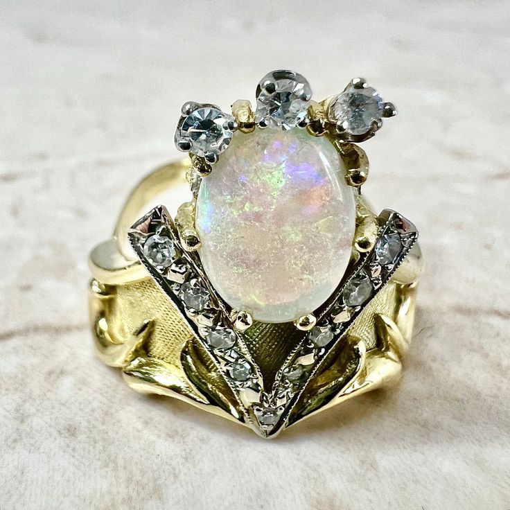 CLEARANCE - 40% OFF! Beautiful vintage 18 karat yellow and white gold ring featuring a fine natural opal cabochon, the birthstone for October ! The gemstone weighs approximately 2 carats, and is surrounded by 12 diamonds weighing approximately 0.30 carat.Diamonds are approximately G-H color SI-I1 clarity. Weighs 7.6 grams. Size 7.25 US / O 1/2 UK / 55 FR. > Ring sizing not included.This ring can be sized to fit most fingers.If you need to size this ring, please contact us before placing the orde Heirloom Gold Opal Gemstone Ring, Unique Yellow Gold Ethiopian Opal Ring, Opal And Moonstone Multi-stone Fine Jewelry Ring, Heirloom Oval Moonstone Ring, Fine Jewelry Opal And Moonstone Multi-stone Ring, Heirloom White Gold Opal Gemstone Ring, Gold Multi-stone Opal Ring With Oval Cabochon, Heirloom Oval Opal Ring With Multi-stone, Heirloom Multi-stone Opal Ring For Anniversary