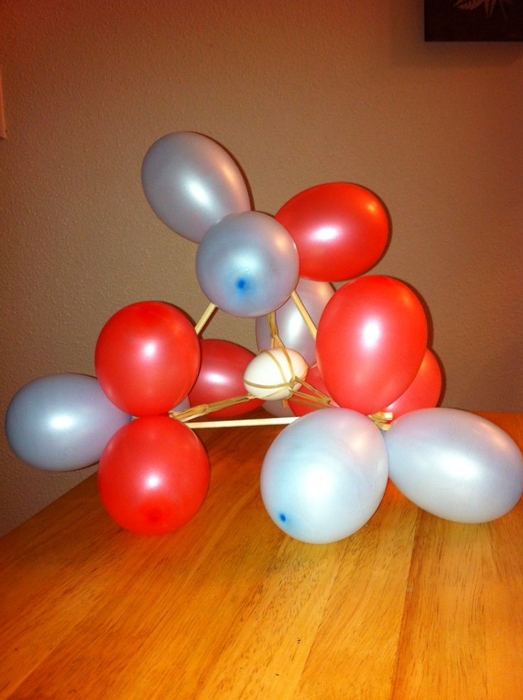 red, white and blue balloons sitting on top of a wooden table