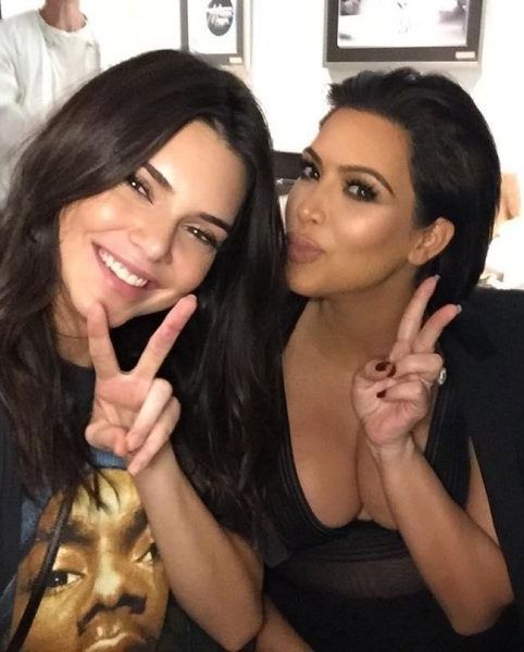 two women making the peace sign with their fingers