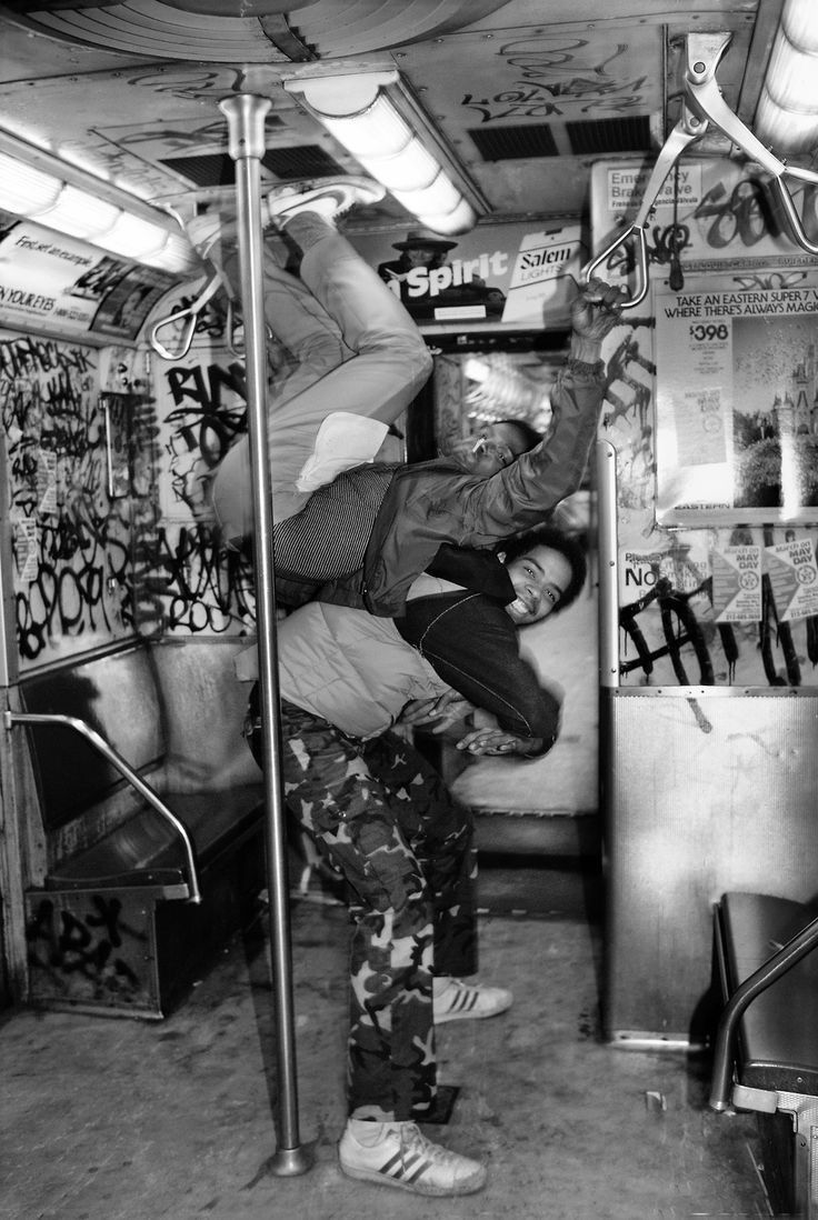 black and white photograph of a person on a bus with graffiti all over the walls