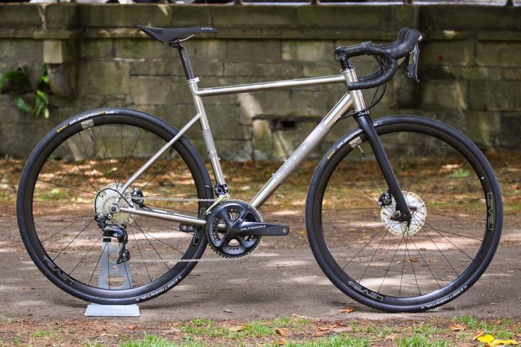 a bike parked on the ground in front of a brick wall