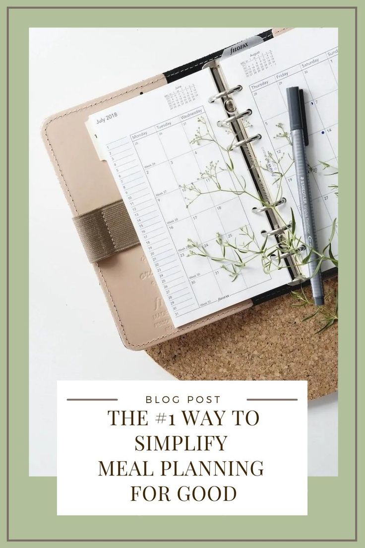 an open planner book sitting on top of a desk next to a pen