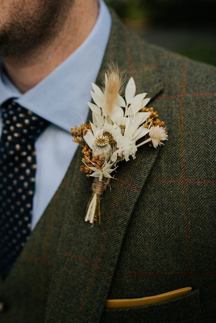 a man wearing a suit and tie with a boutonniere on his lapel