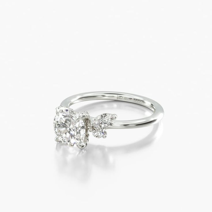 a diamond engagement ring with three stones on the top and bottom, set in 18k white gold