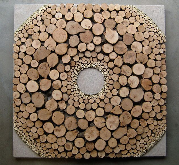 there is a circular design made out of wood logs on the floor and in the center