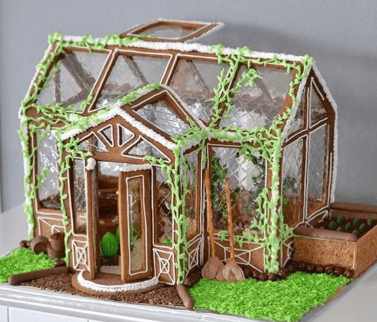 a cake that looks like a house with green grass on the outside and windows in the inside