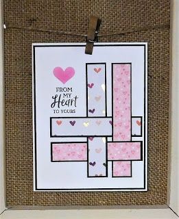 a white frame holding a card with pink hearts on it and a heart hanging from the front