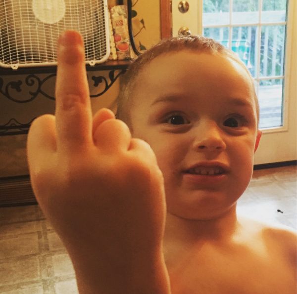 a young boy making the v sign with his fingers