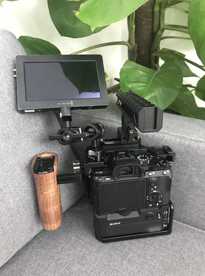 the camera is sitting on the couch with its tripod mounted to it's side