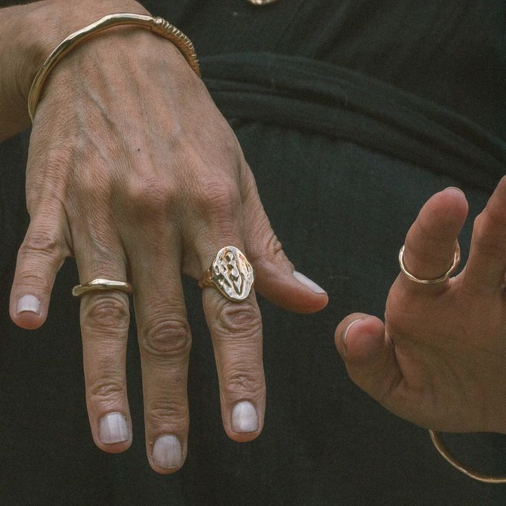 two people with rings on their fingers and one is holding the other's hand