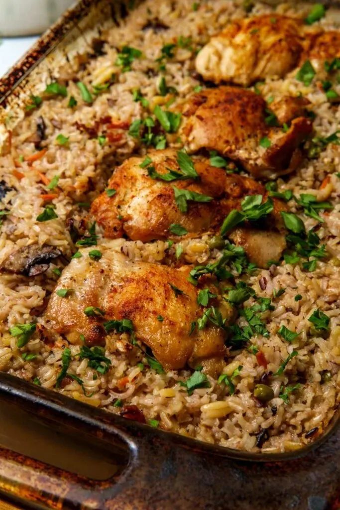 chicken and rice dish in a pan with garnishes on the side, ready to be eaten