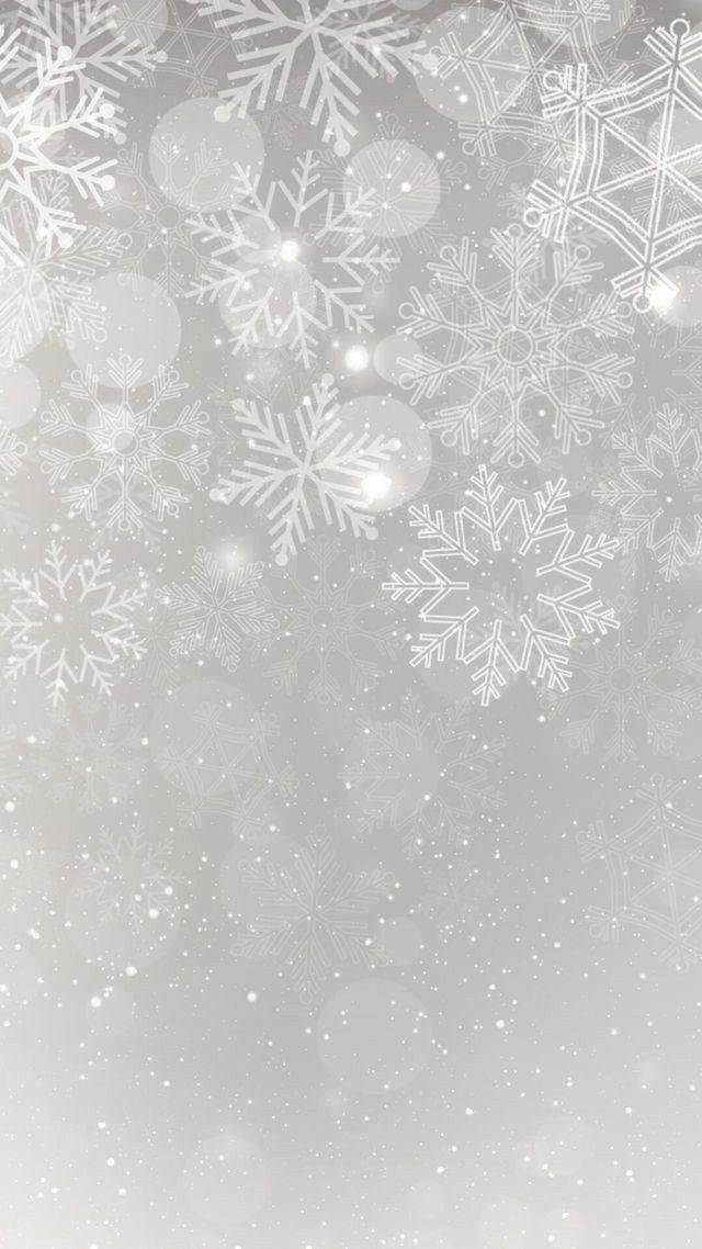 snowflakes are falling down on the ground in front of a gray background with white lights