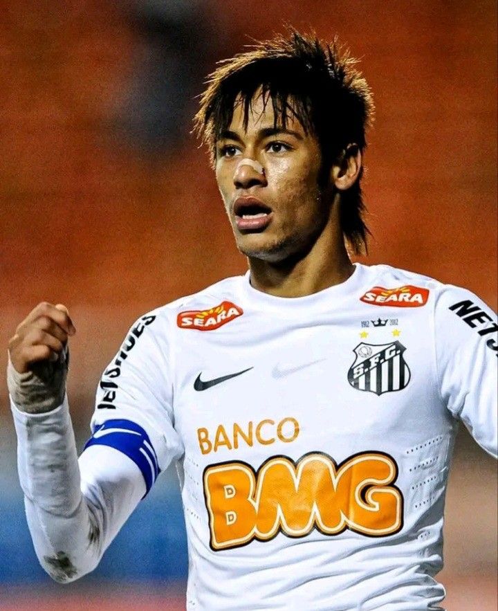 a soccer player is holding his fist up and looking at the camera with an angry look on his face