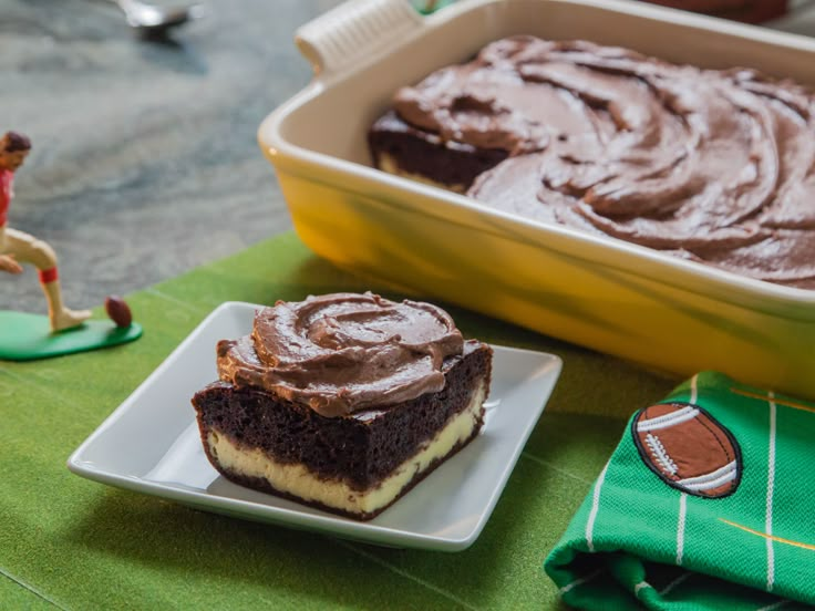 a piece of cake on a plate next to a bowl of chocolate frosted cake