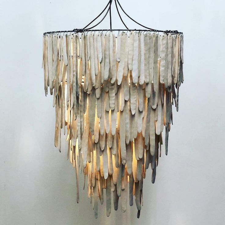 a chandelier made out of shells hanging from the ceiling