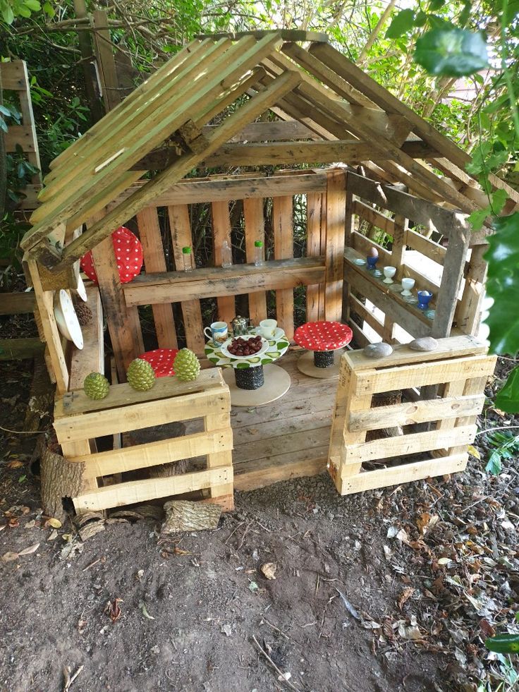 a small wooden house made out of pallets and wood planks with plants in it