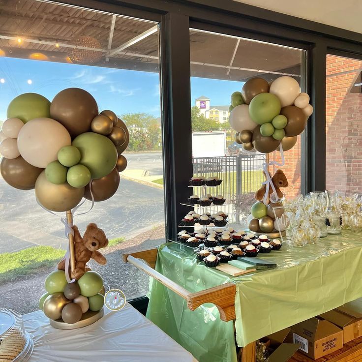 a table filled with cupcakes and balloons