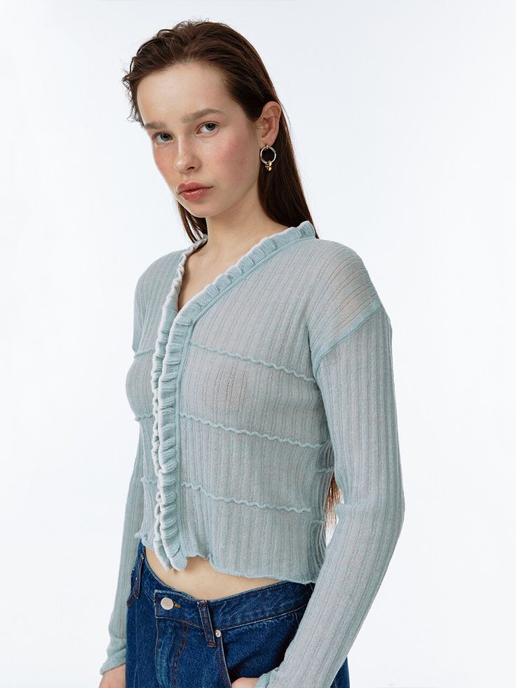 a woman in jeans and a sweater posing for the camera with her hands on her hips