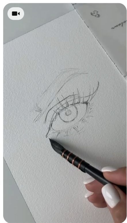 someone is drawing an eye with a pencil