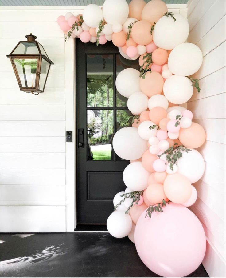 the balloon arch is decorated with pink, white and light pink balloons for an outdoor party