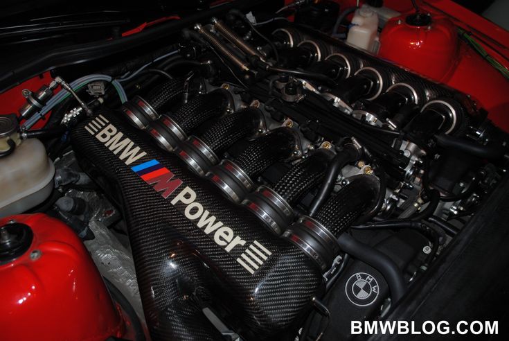 the engine compartment of a race car with its hood up and it's hoses down