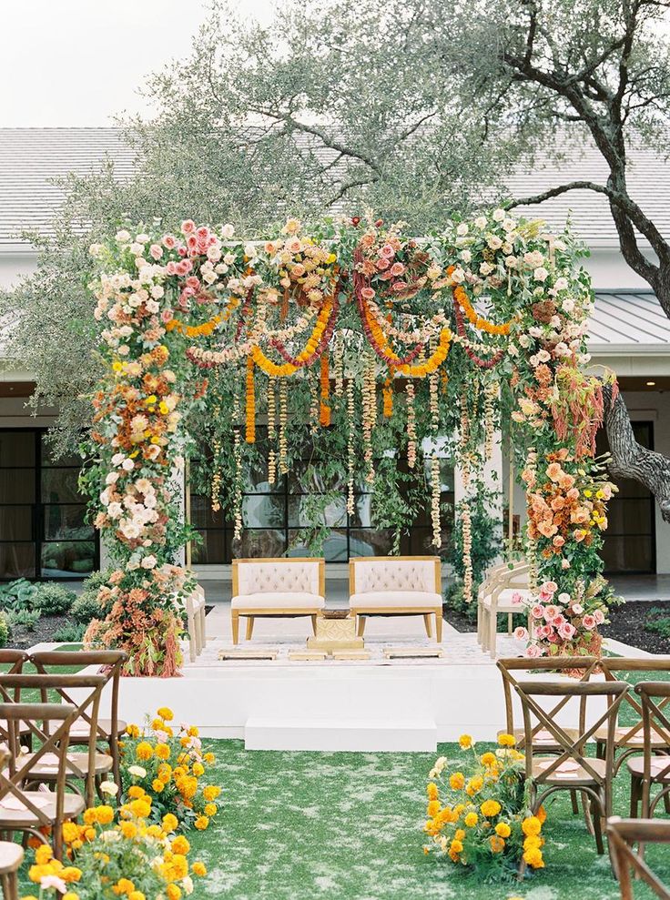 an outdoor ceremony setup with flowers and greenery on the altar, surrounded by chairs