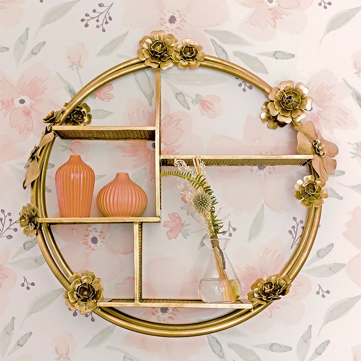 a gold frame with flowers and vases on it in front of a floral wallpaper