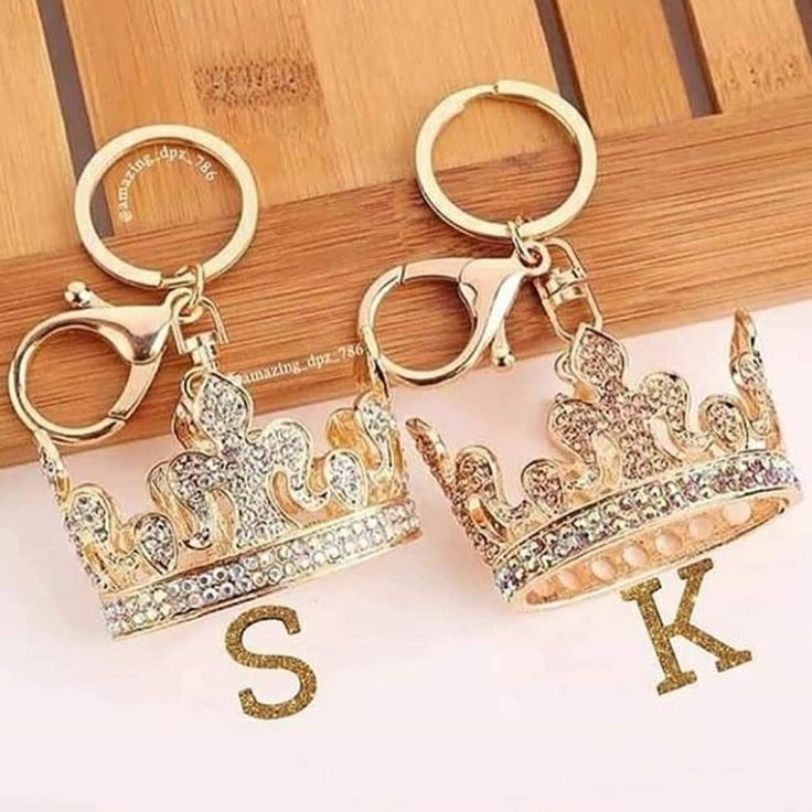 two keychais with crowns on them and the letter s is spelled in gold