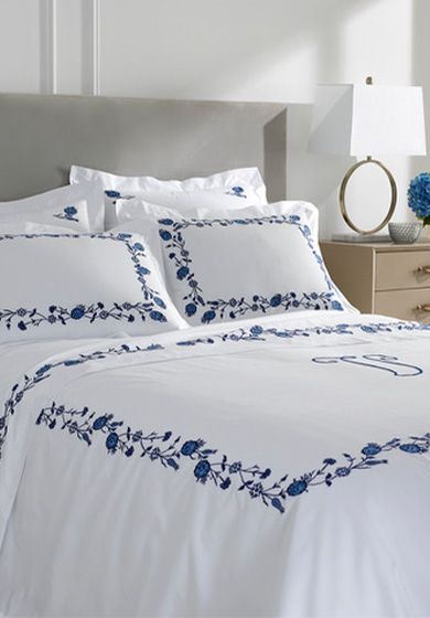 a white bed with blue flowers on it